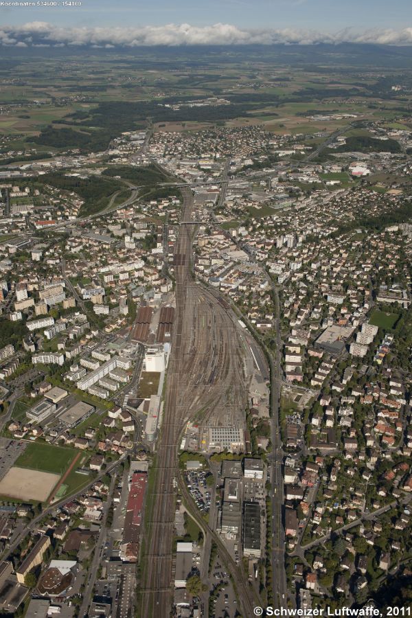 Lausanne Renens, Güterbahnhof (Blickrichtung NW; Position: 2'534'607.58, 1'154'154.59). Bildmitte: Autobahnbrücke A1; dahinter: Stadtteil Bussigny.